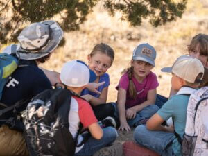 Campers sit in a circle outdoors