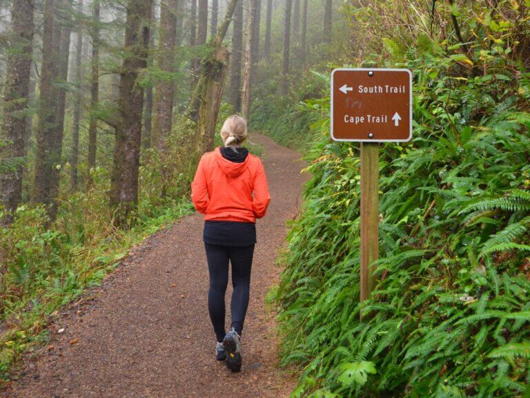 A woman hikes on a forested trail