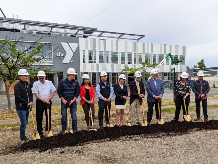 dignitaries hold shovels in preparation for symbolic groundbreaking